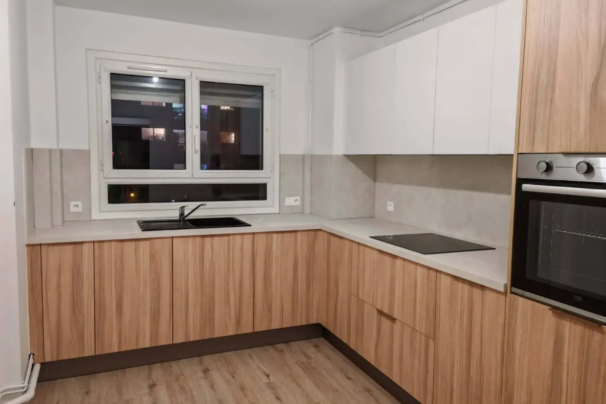 Résultat final : une cuisine lumineuse alliant façades bois clair et plan de travail blanc.